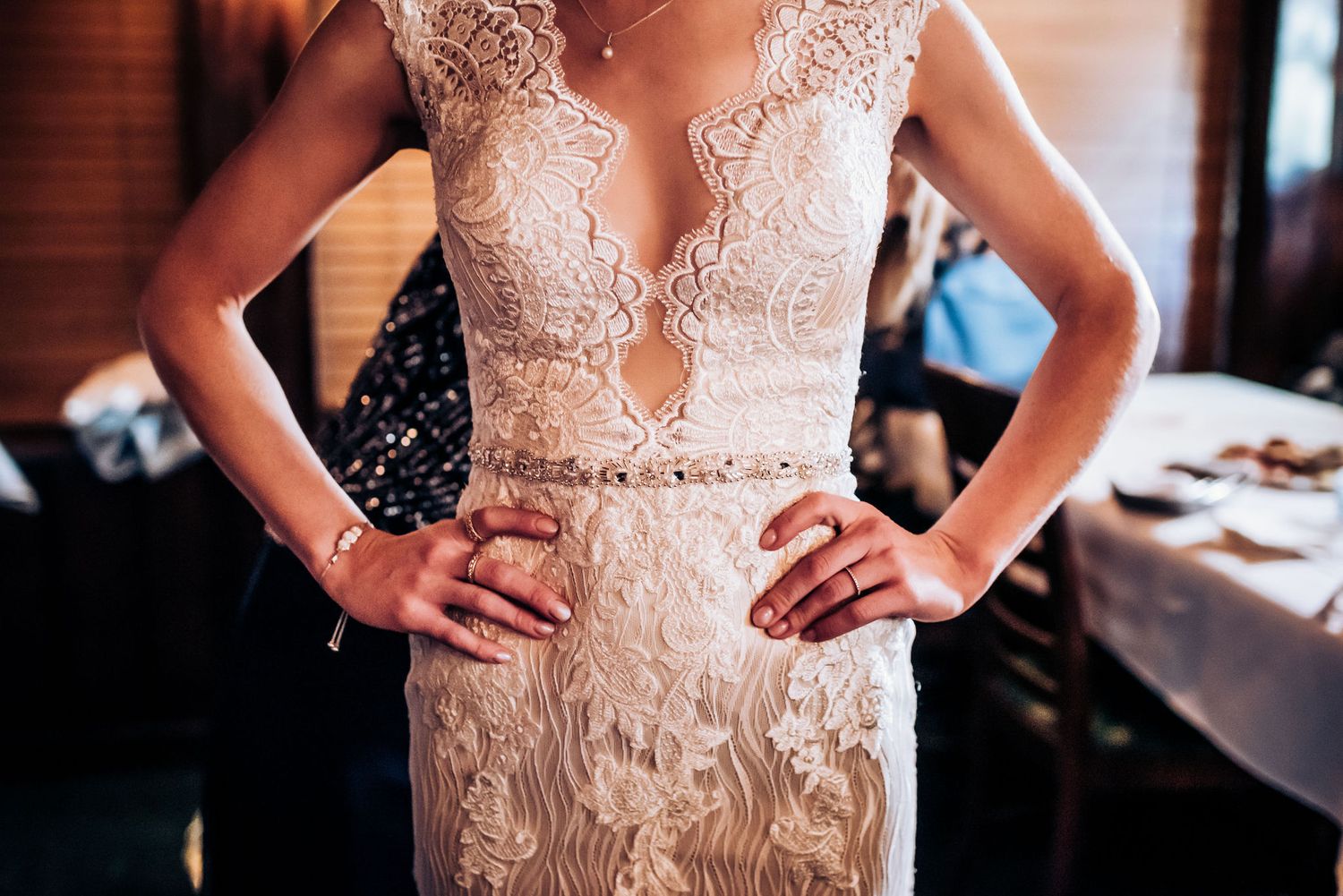 Detailed shot of an intricate lace wedding dress with plunging neckline and beaded details.