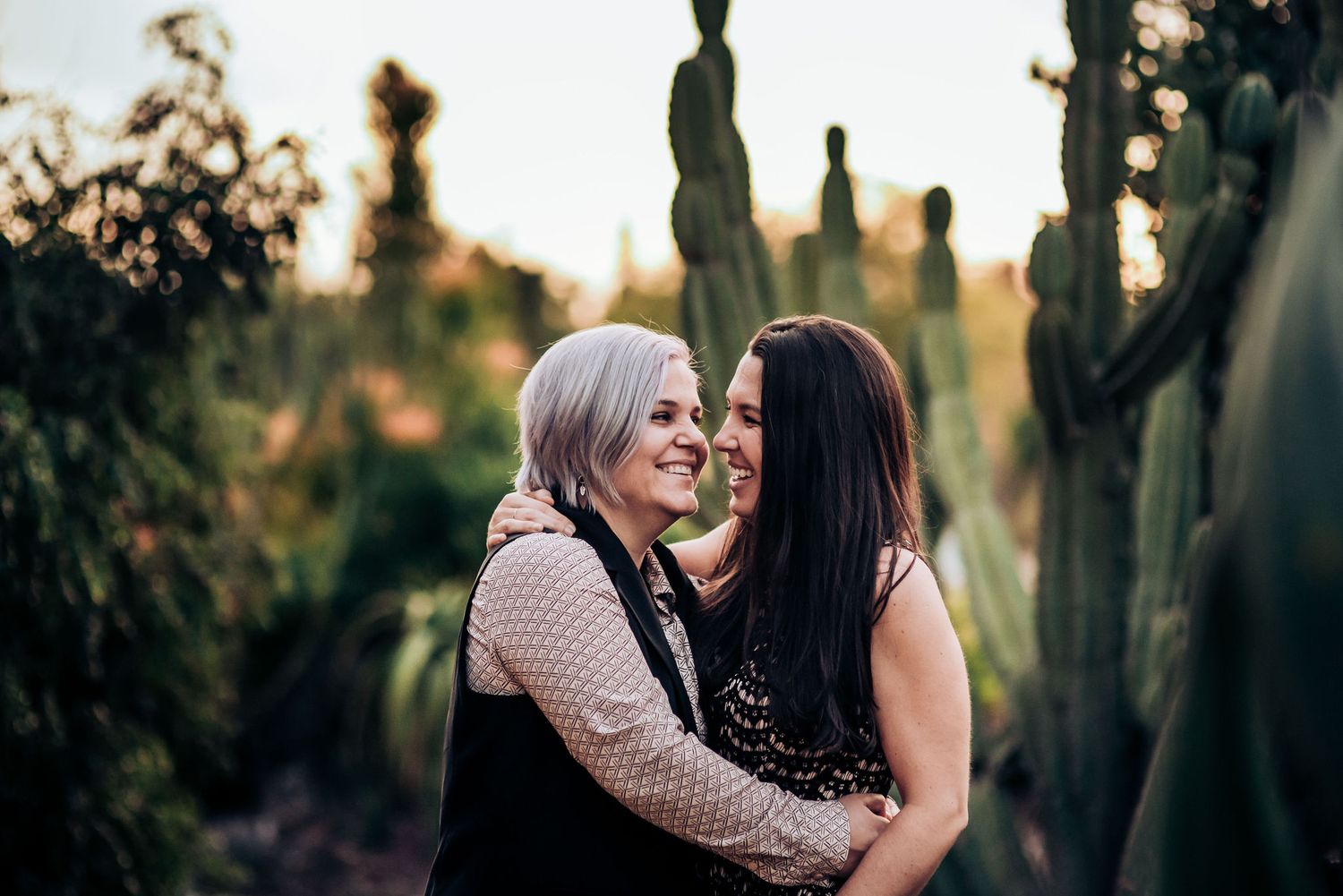 A tender moment captured between a couple in a desert botanical garden setting.