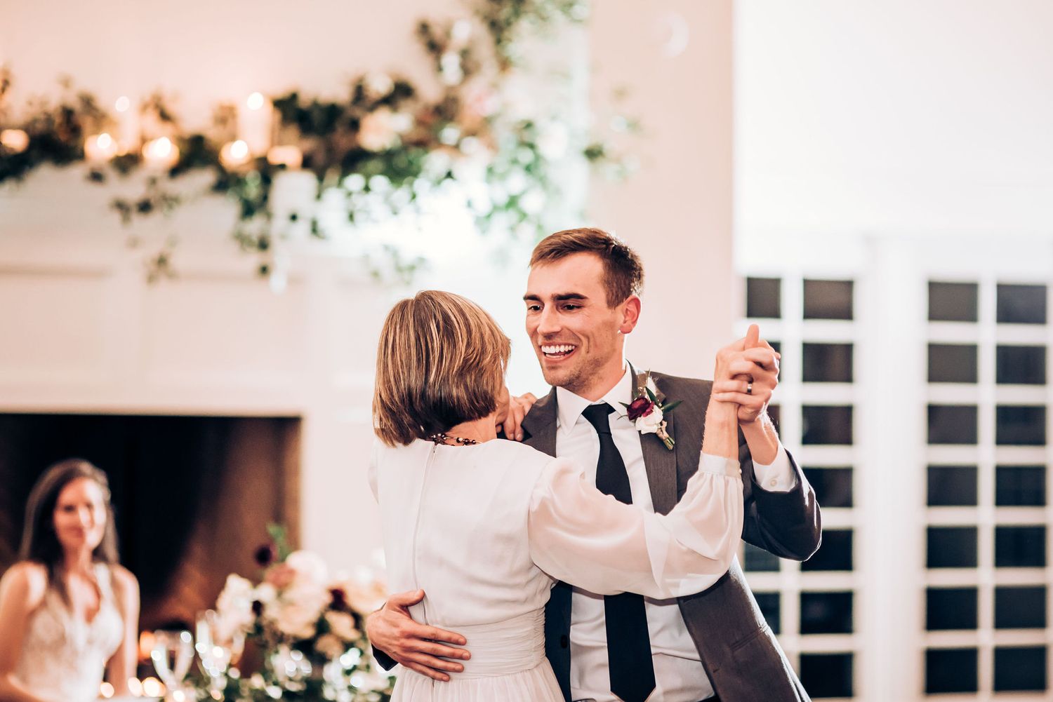 A joyful dance moment during a wedding reception in an elegant white-walled venue.