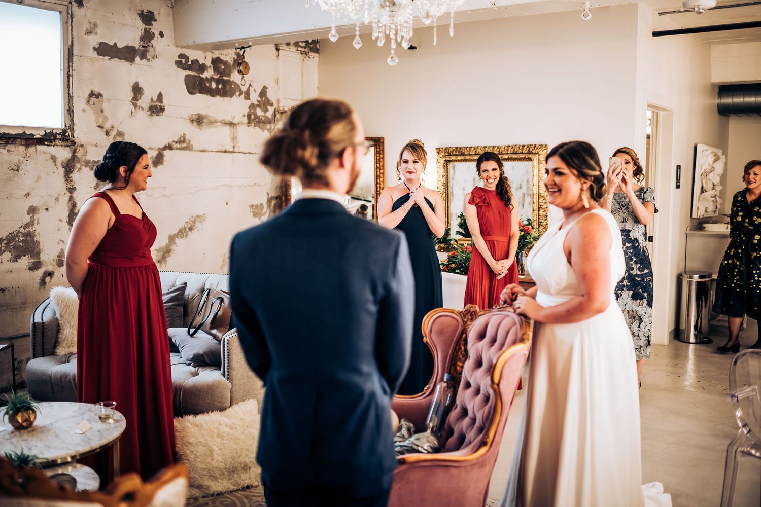 Wedding ceremony in a rustic indoor venue with distressed walls and elegant decor.