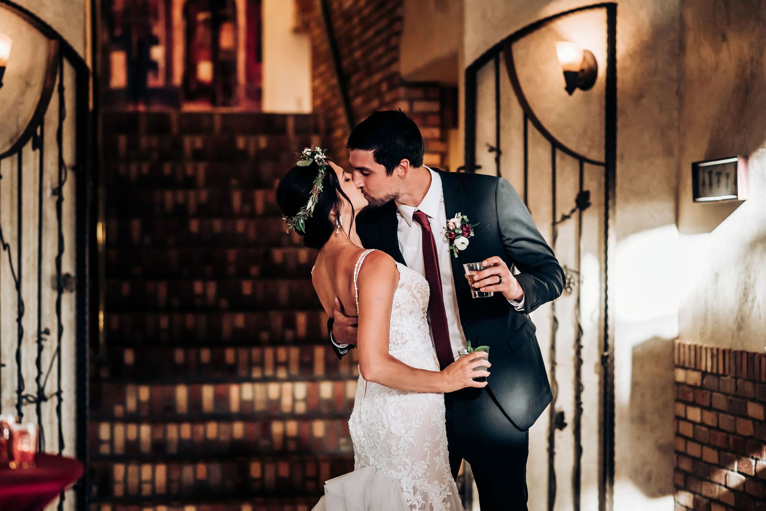 Romantic moment captured on an ornate staircase in an elegant venue.