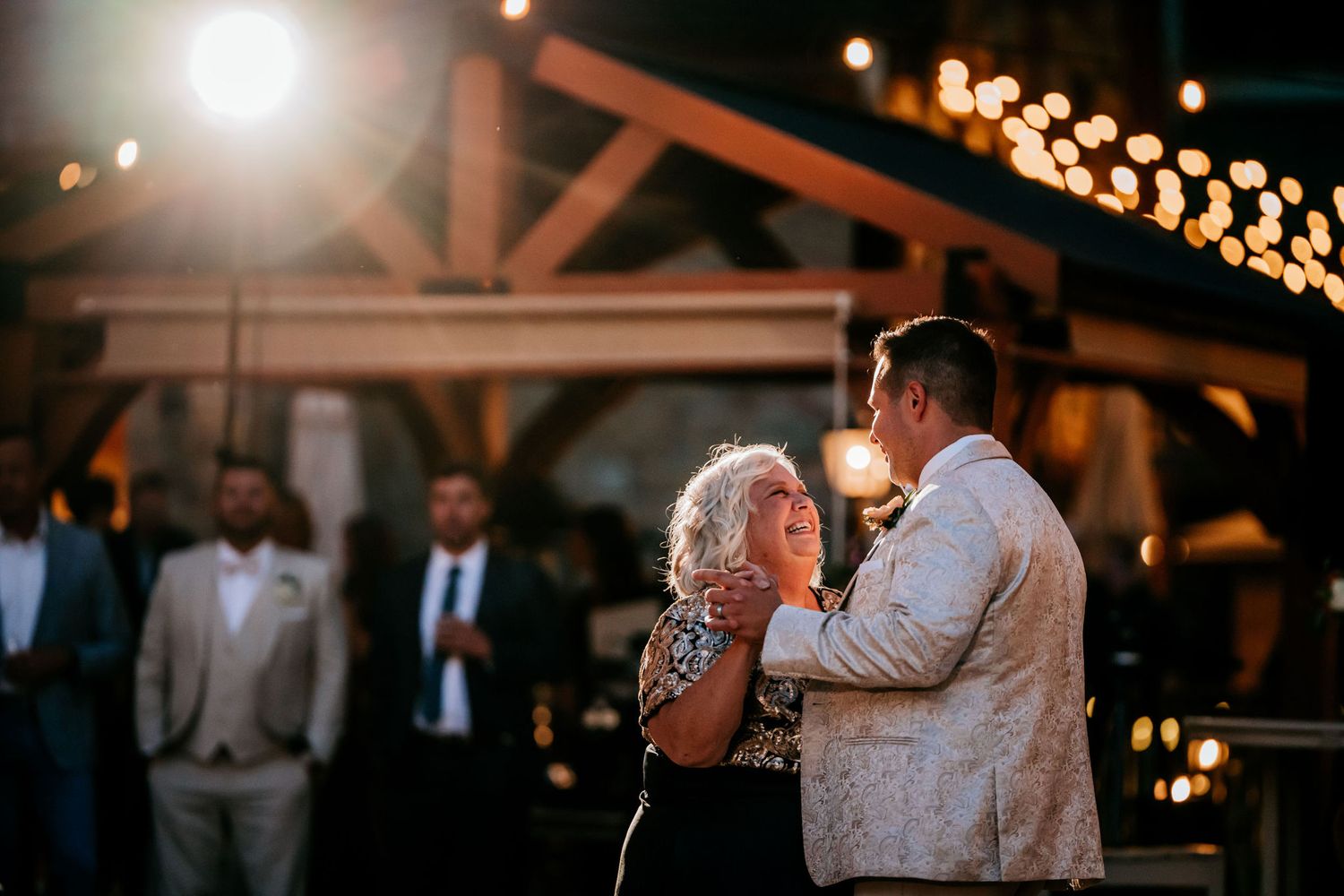 Couple sharing a dance moment under warm lights at an evening reception.