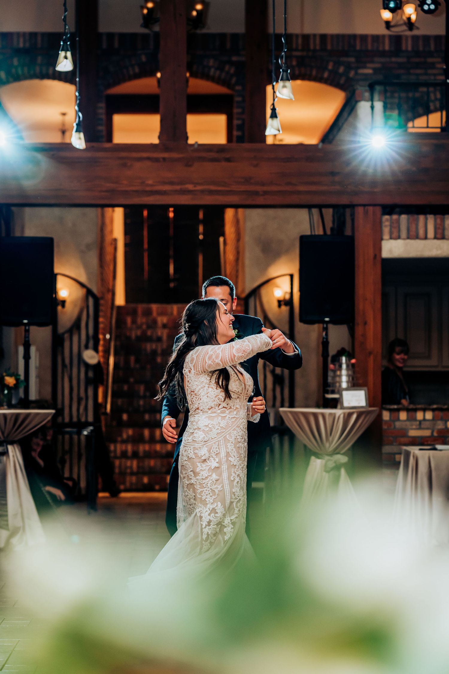 Wedding dance captured through decorative elements with soft lighting and wooden architectural details.