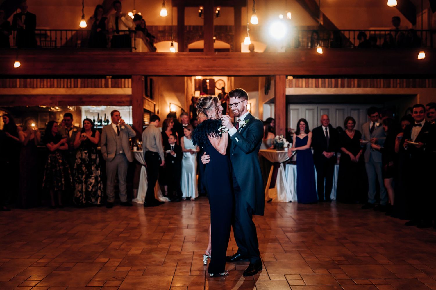 A slow dance captured in warm lighting at an evening wedding celebration.
