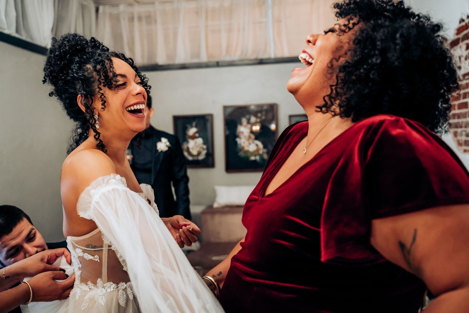 Joyful moment shared between wedding party members during preparations.