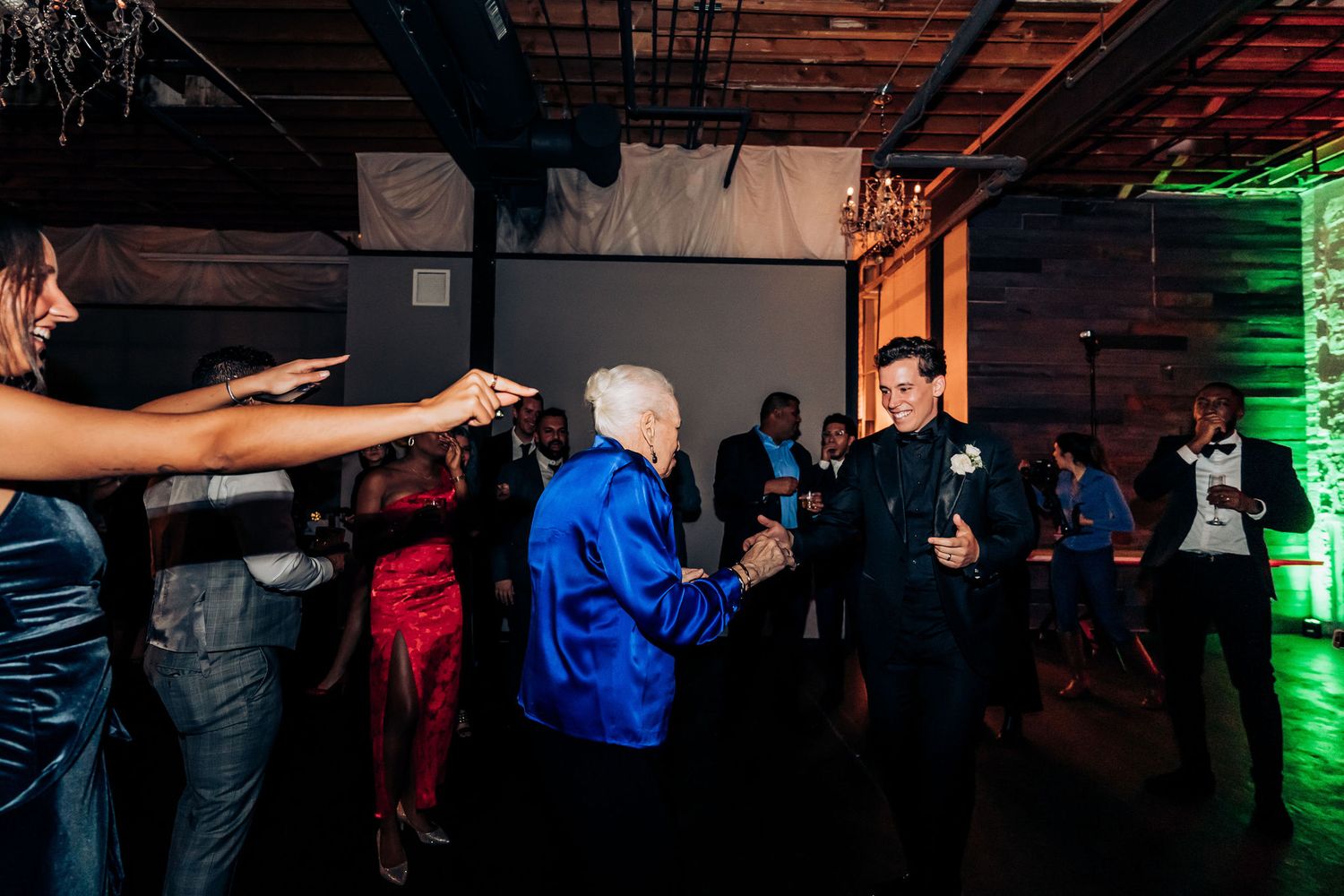 Wedding reception dance floor filled with guests enjoying lively celebration.