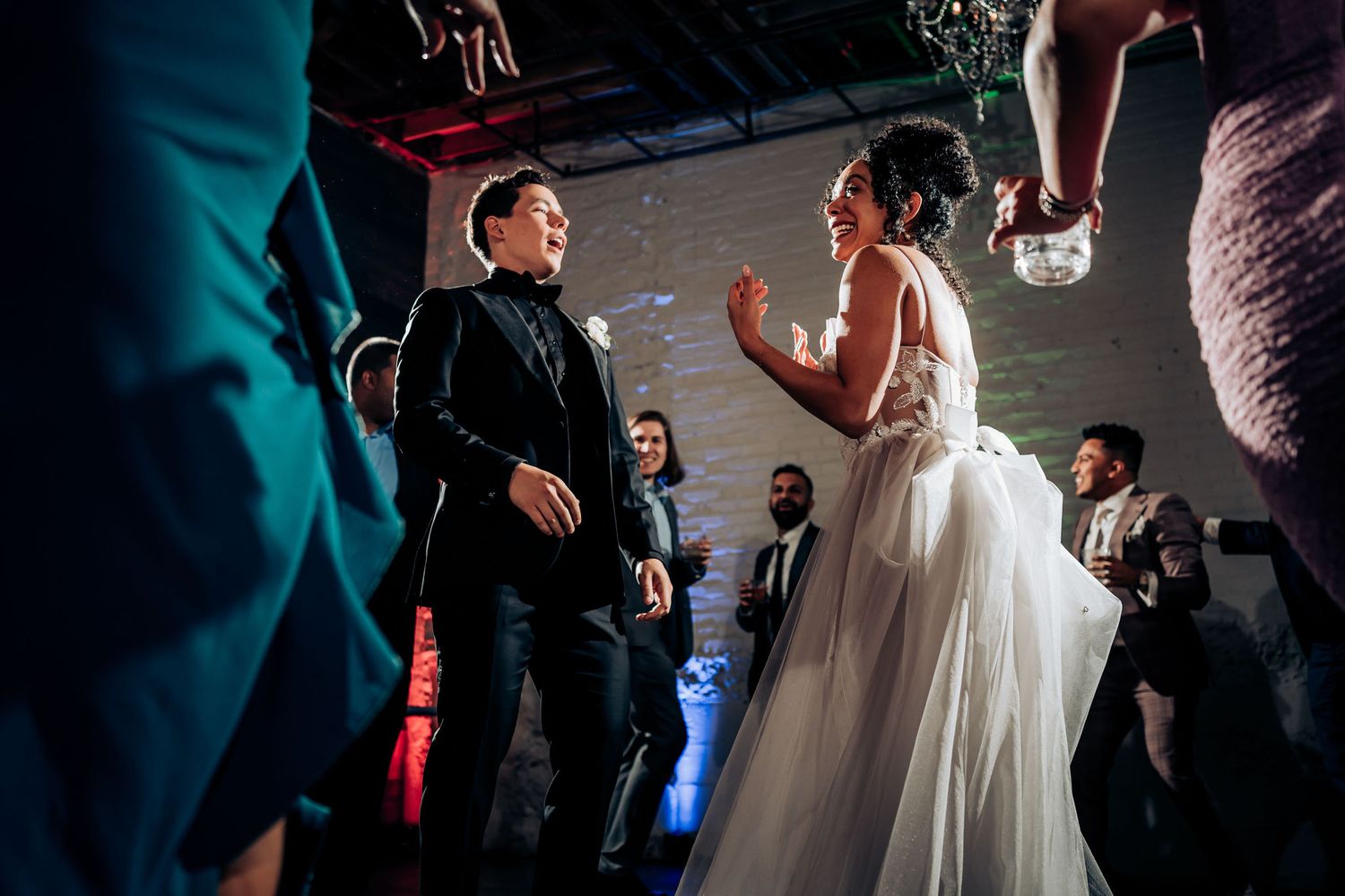 Two wedding guests dance face-to-face during lively reception celebration.