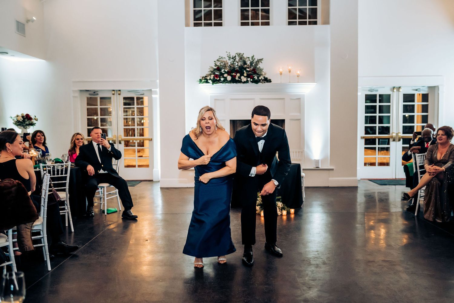 Couple performs special dance routine at wedding reception while guests look on.