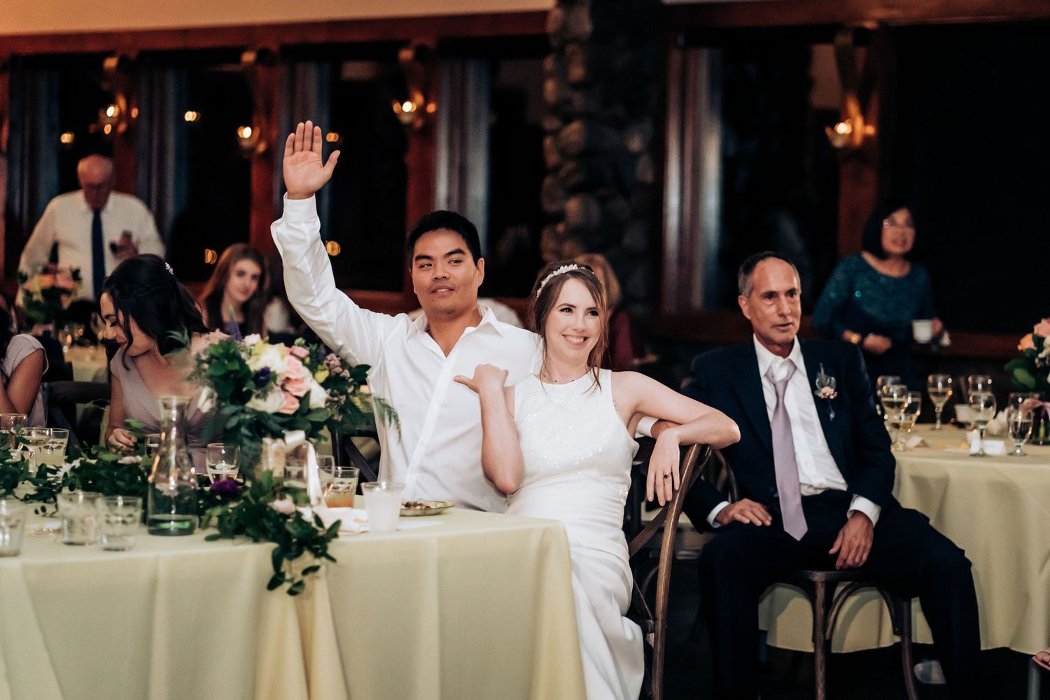 Wedding guests raise their hands during a celebratory moment at the reception.