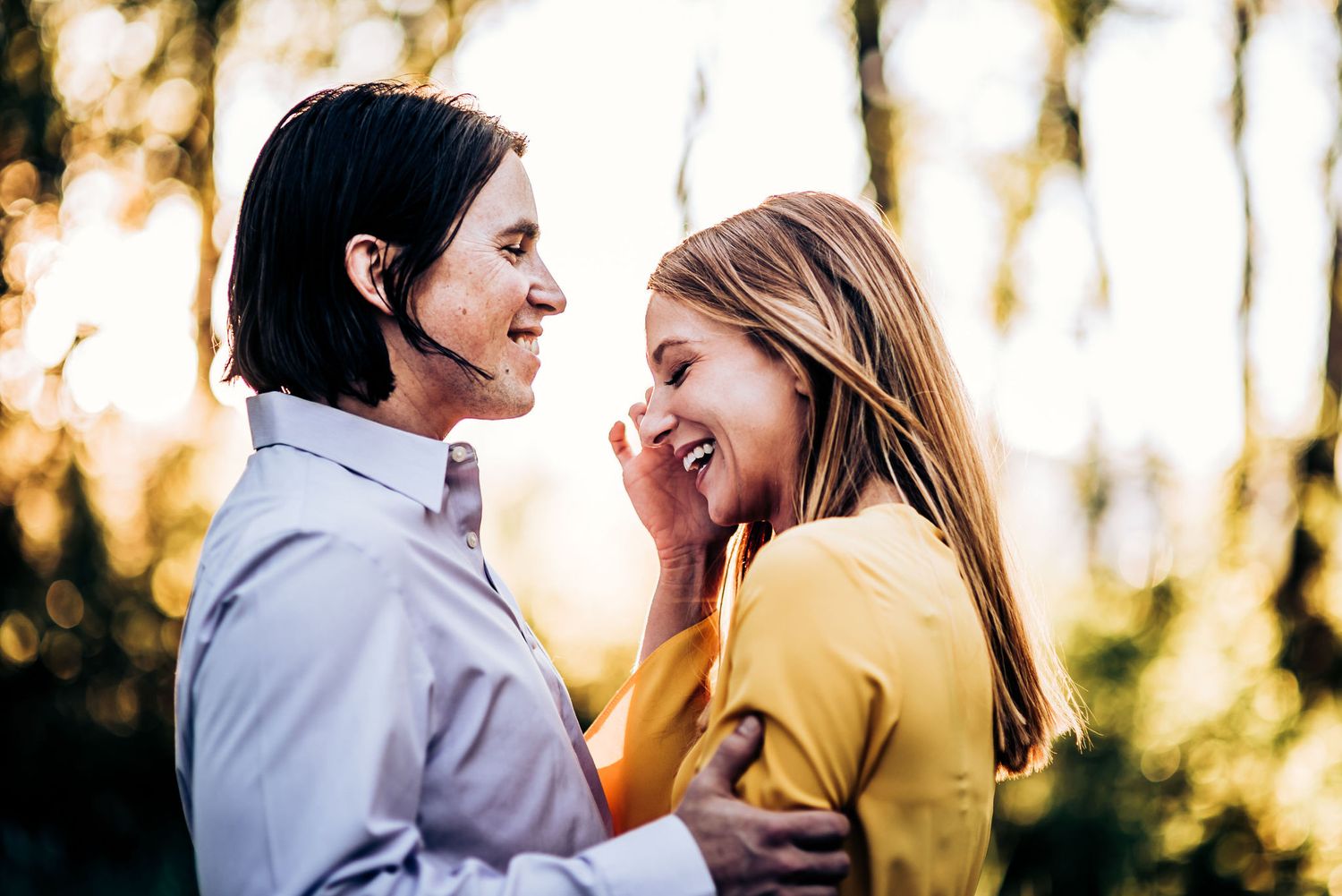 A romantic moment between a couple in a yellow dress and white shirt during sunset.