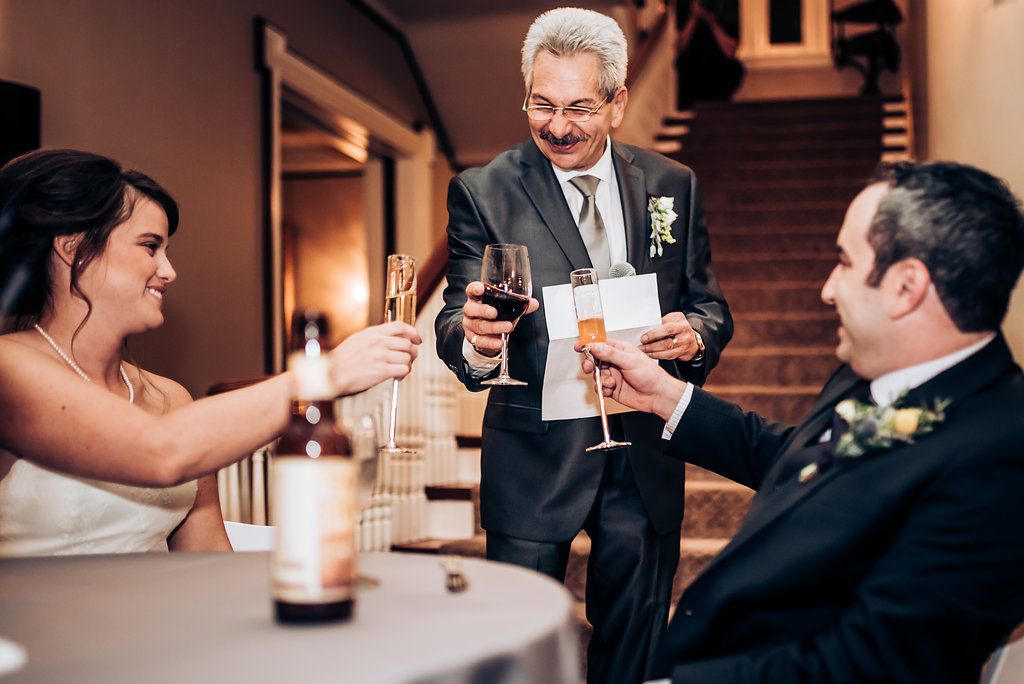 Wedding celebration toasts with champagne glasses at an intimate reception gathering.