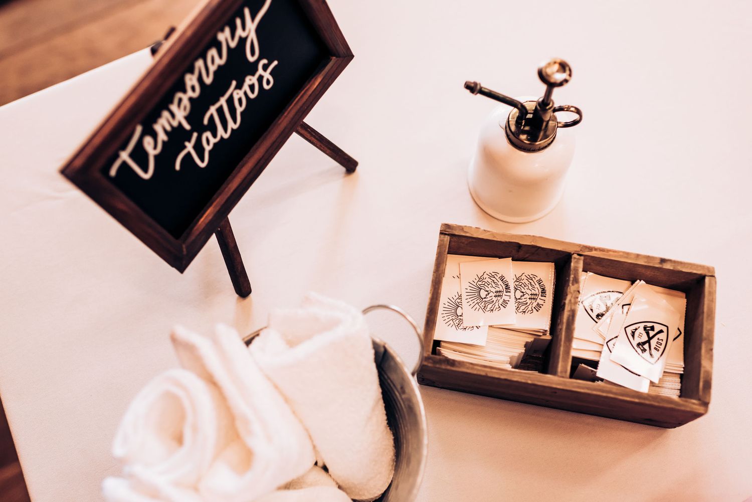 Wedding decorations including a wooden sign and white ceramic accessories on a rustic table.