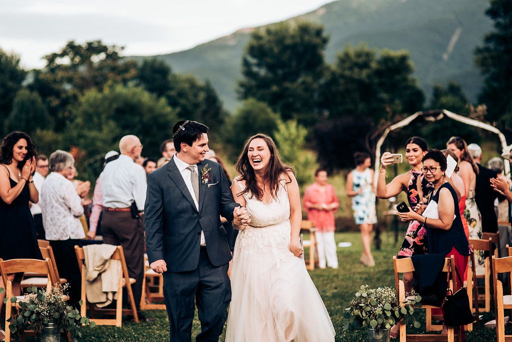A joyful celebration at an outdoor wedding ceremony with mountains in the background.
