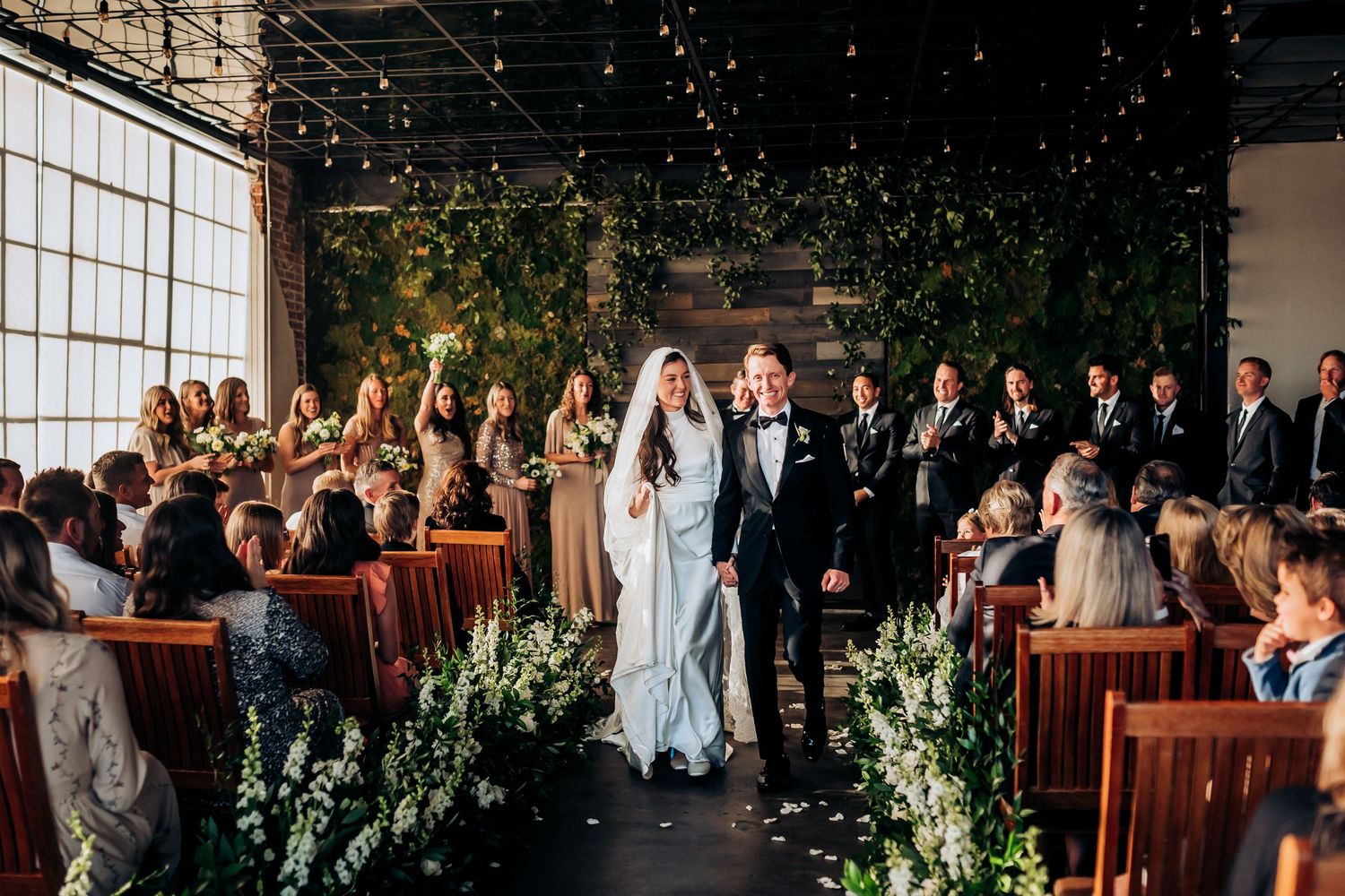 Indoor wedding ceremony venue decorated with string lights and greenery for an intimate celebration.