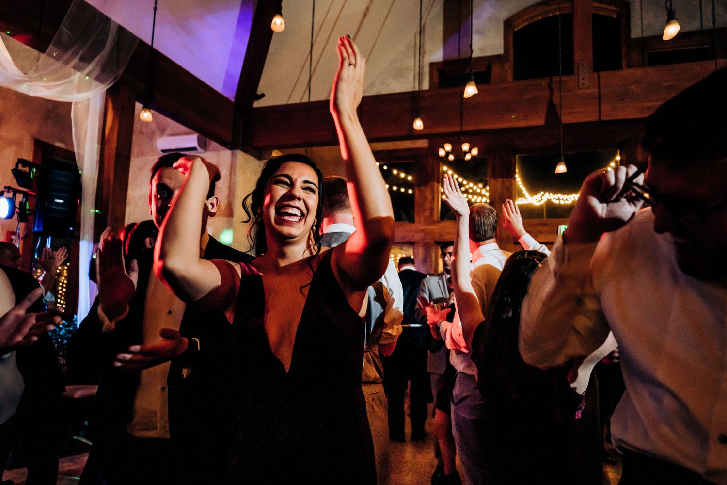 Joyful celebration with guests dancing enthusiastically at an indoor venue.