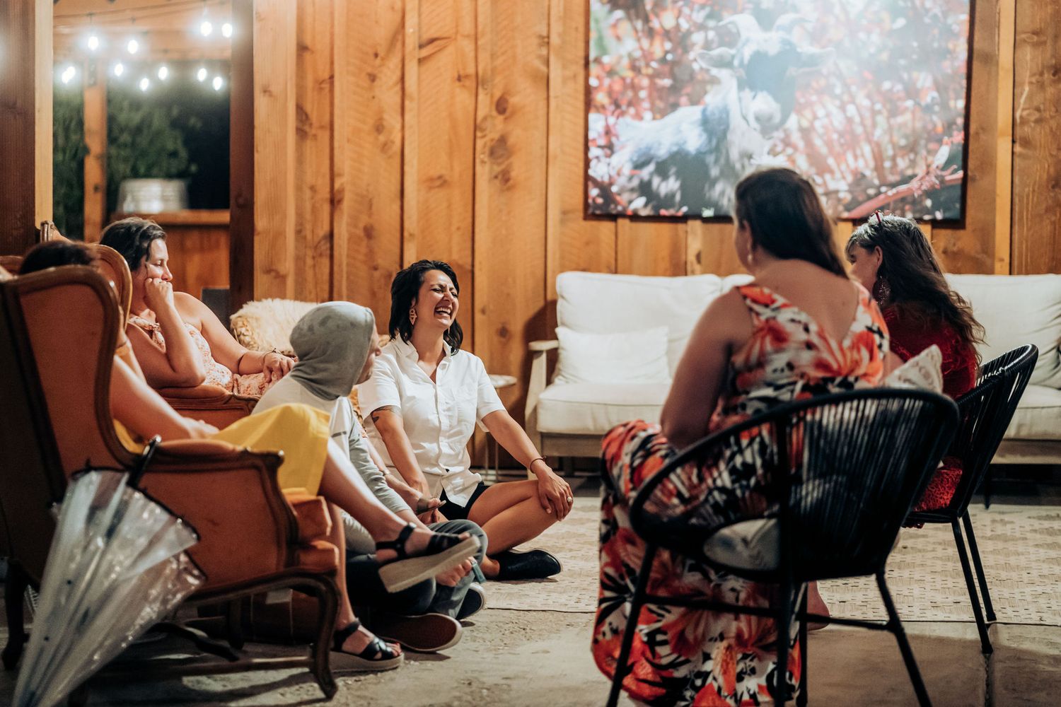 Group enjoying conversation in a cozy wood-paneled room with comfortable seating.