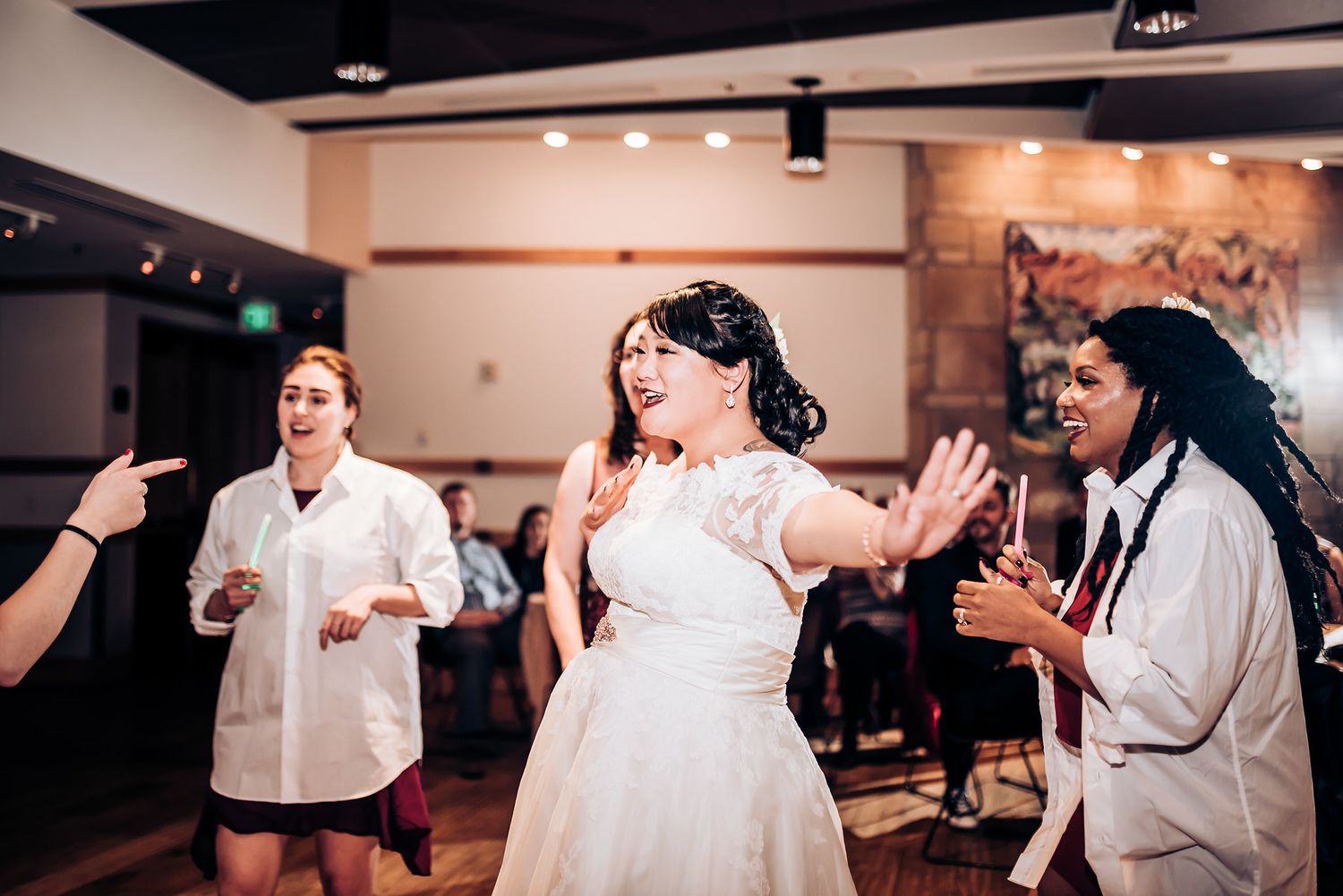 Wedding reception celebration with dancing and joyful movement on a dance floor.