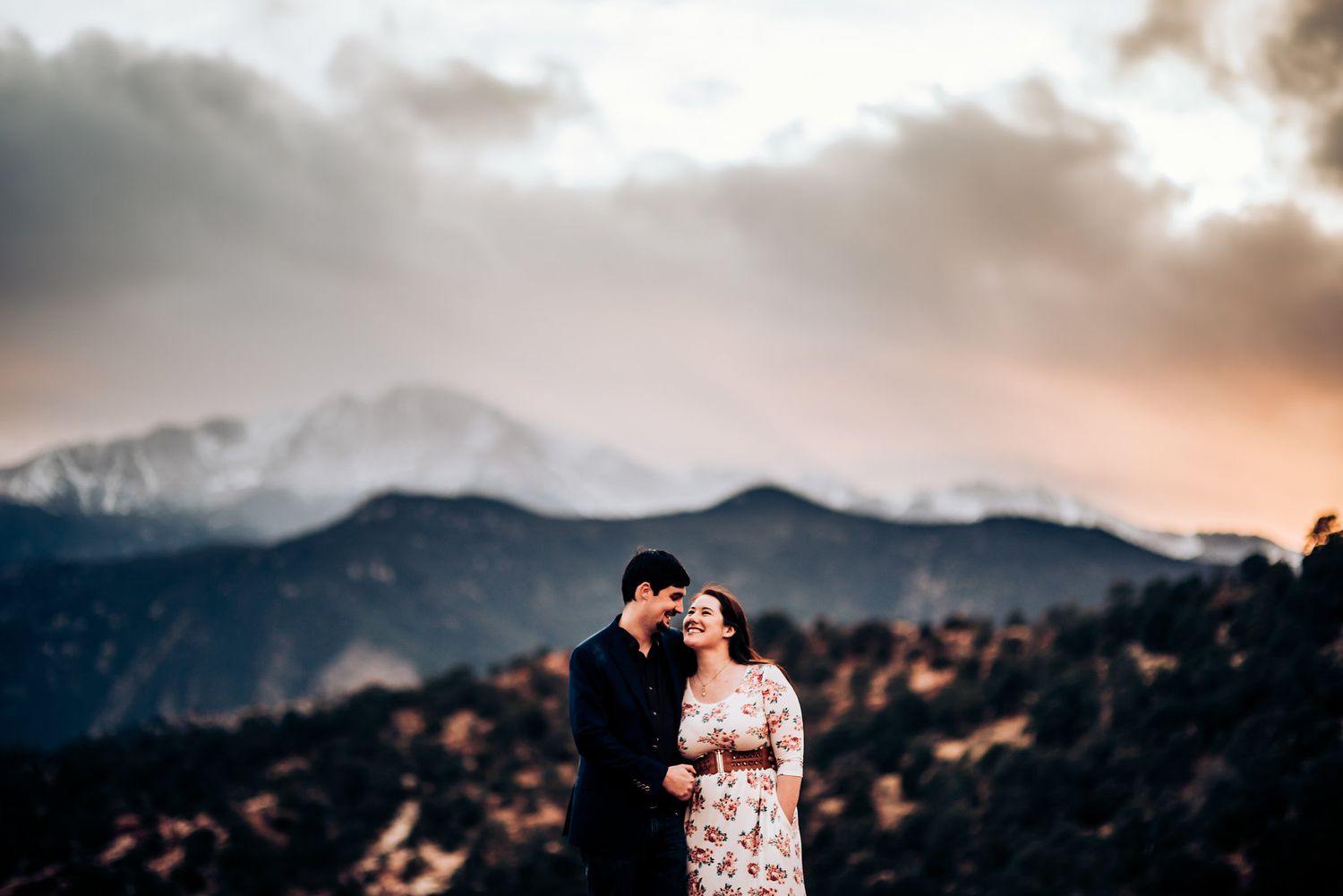 Romantic silhouette of couple against mountain landscape at sunset.