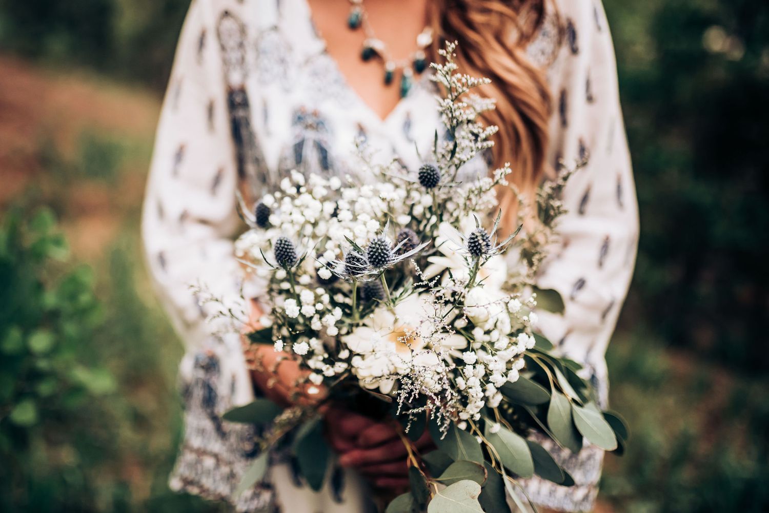 Delicate white and green bridal bouquet with rustic wildflower elements.