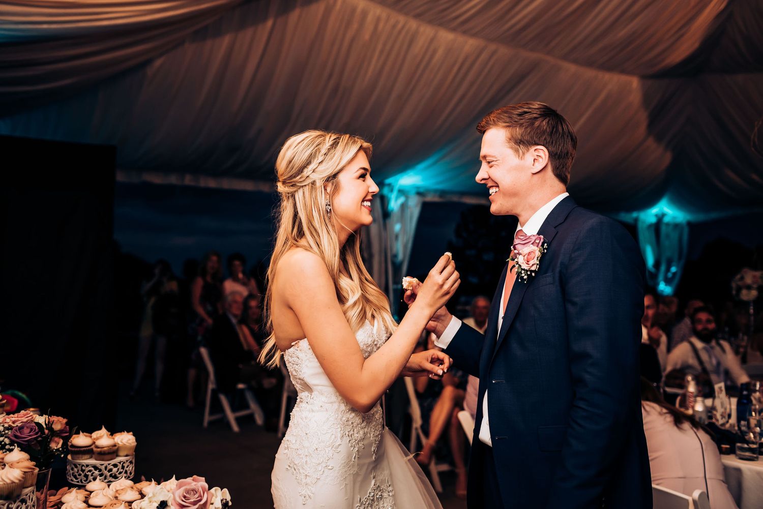 A joyful moment shared between wedding couple after feeding each other cake at their reception.