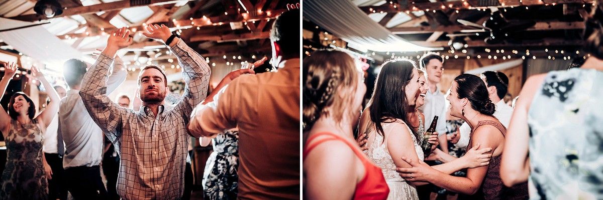 Energetic crowd dances and celebrates under decorative lighting at an indoor party.
