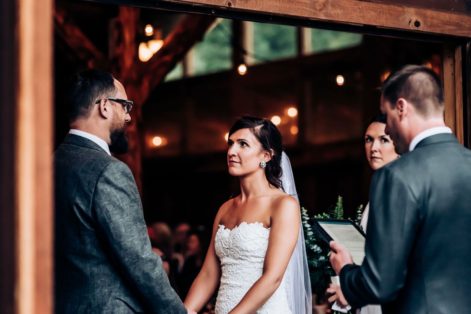 An intimate wedding ceremony moment showing the exchange of vows in a rustic venue.
