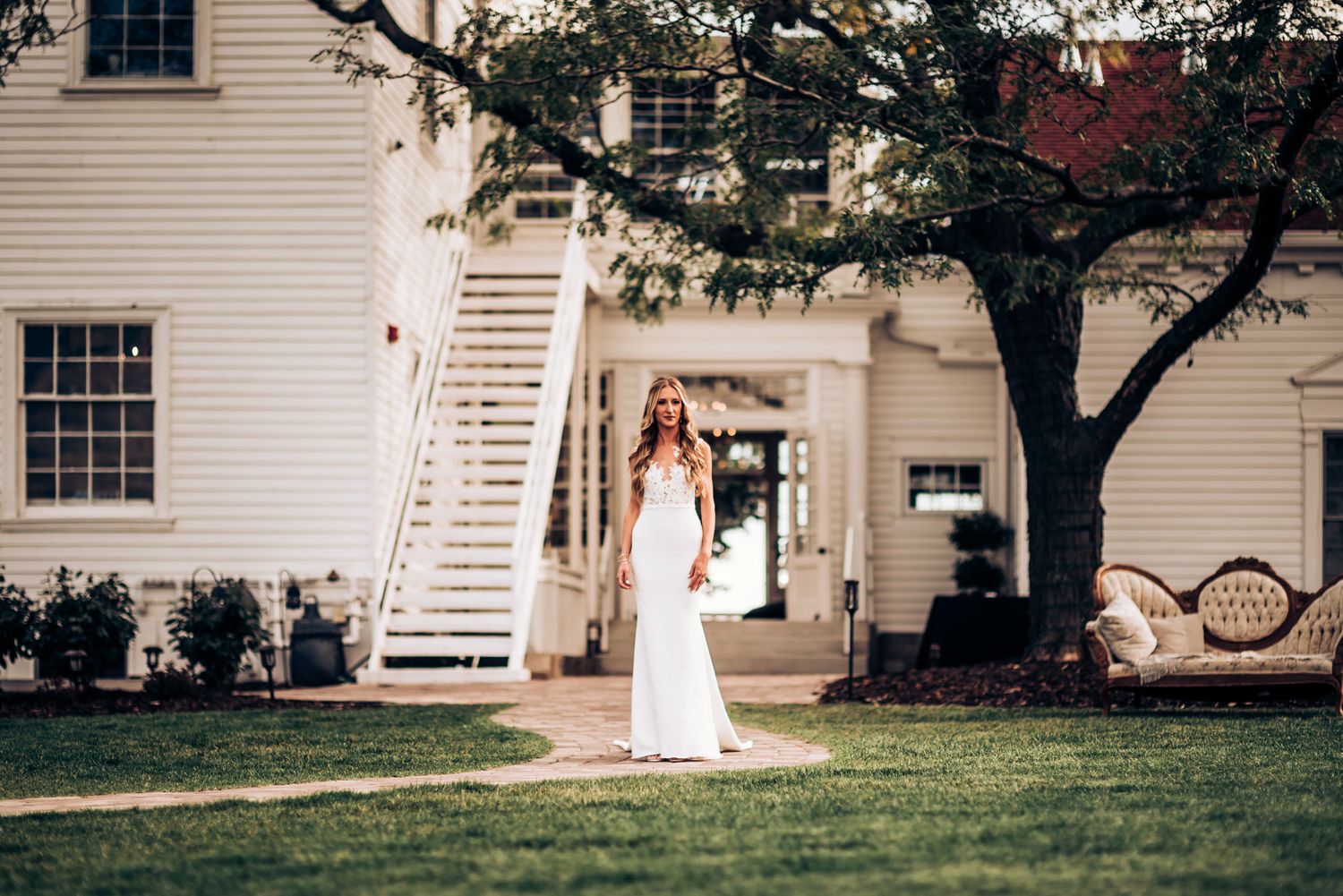 Classic white wedding dress portrait in front of historic building with exterior staircase.