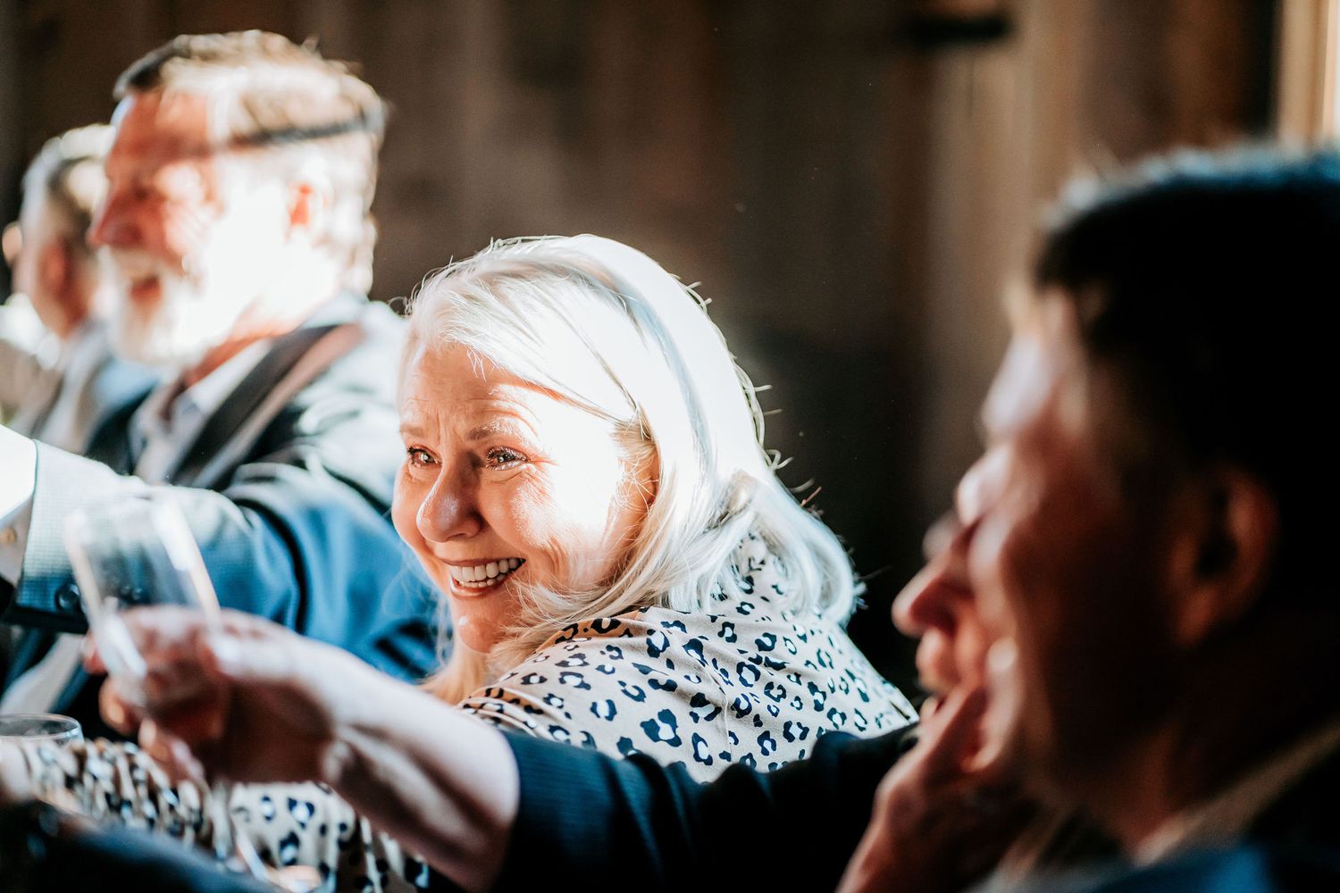 Guests share genuine smiles during a lighthearted moment at a reception dinner.
