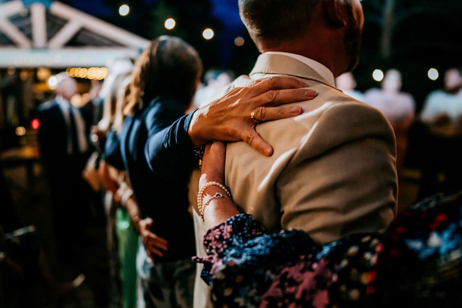 Close-up of dancing hands during an evening wedding reception.