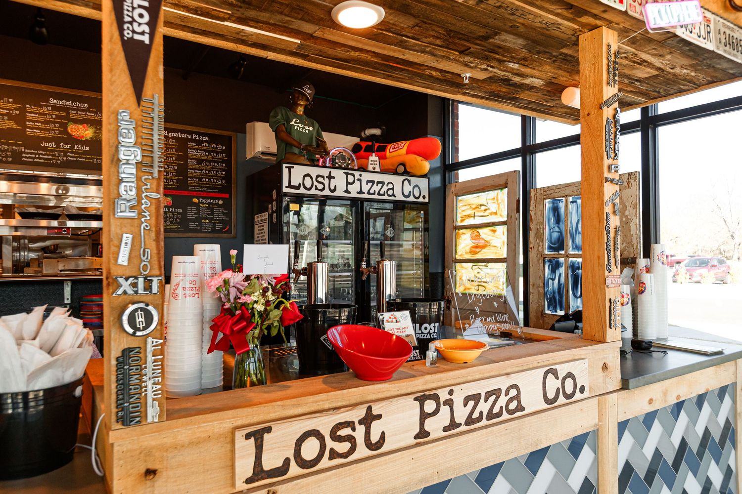 Counter service area of Lost Pizza Co. with rustic wood decor and holiday decorations.