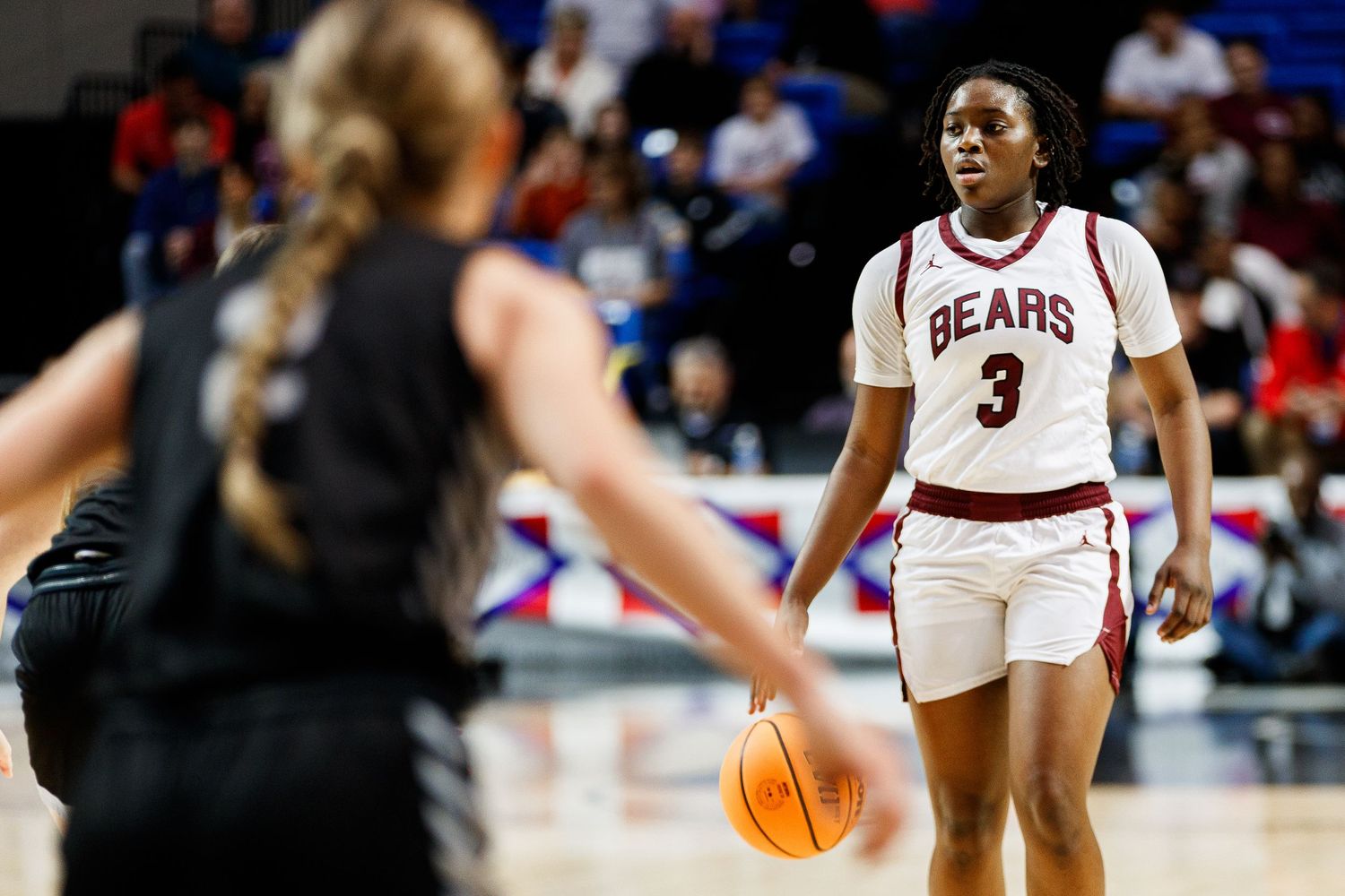 Basketball player in a Bears jersey controls the ball on the court.