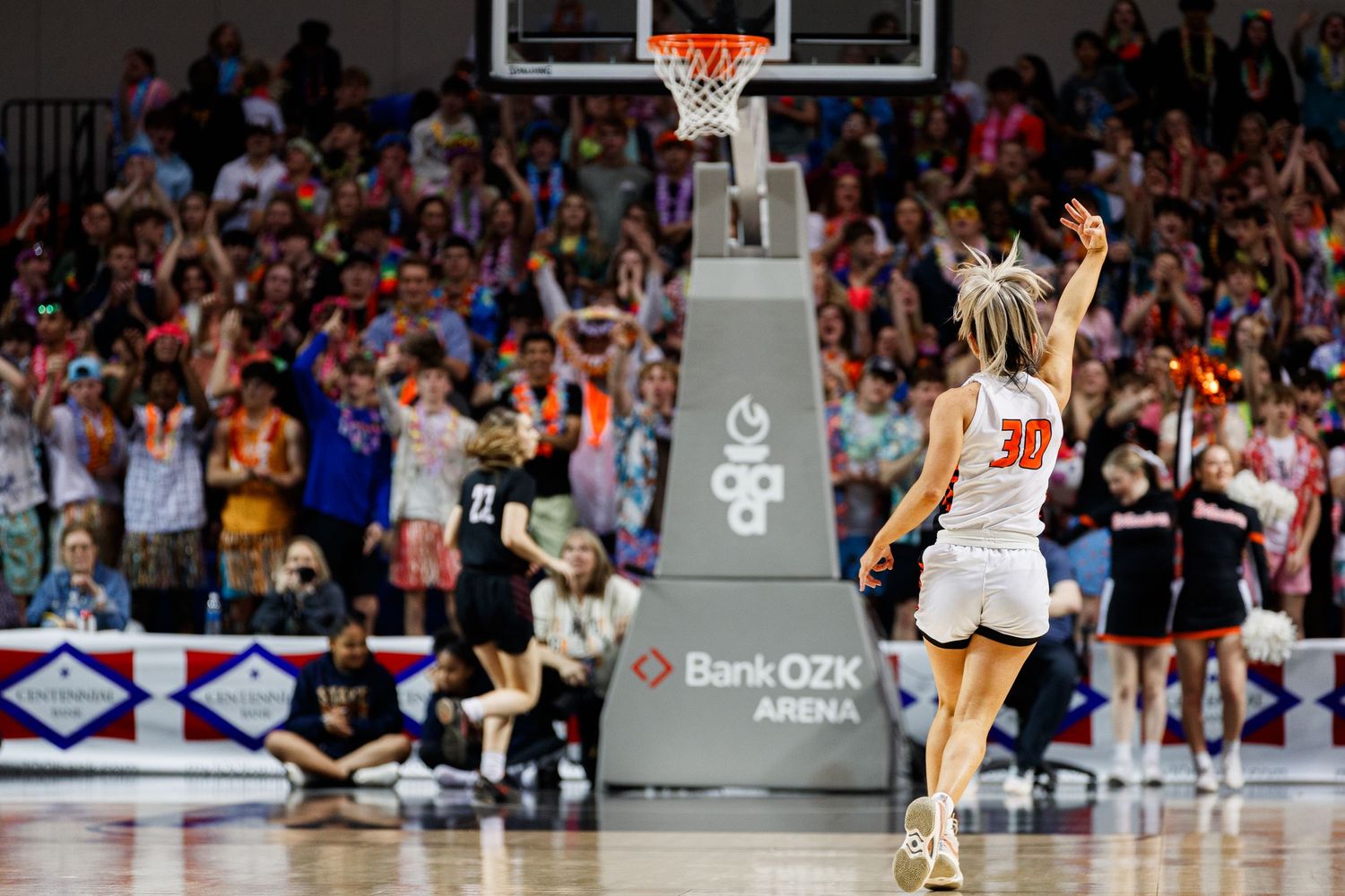 Basketball players competing under the hoop during intense game action.