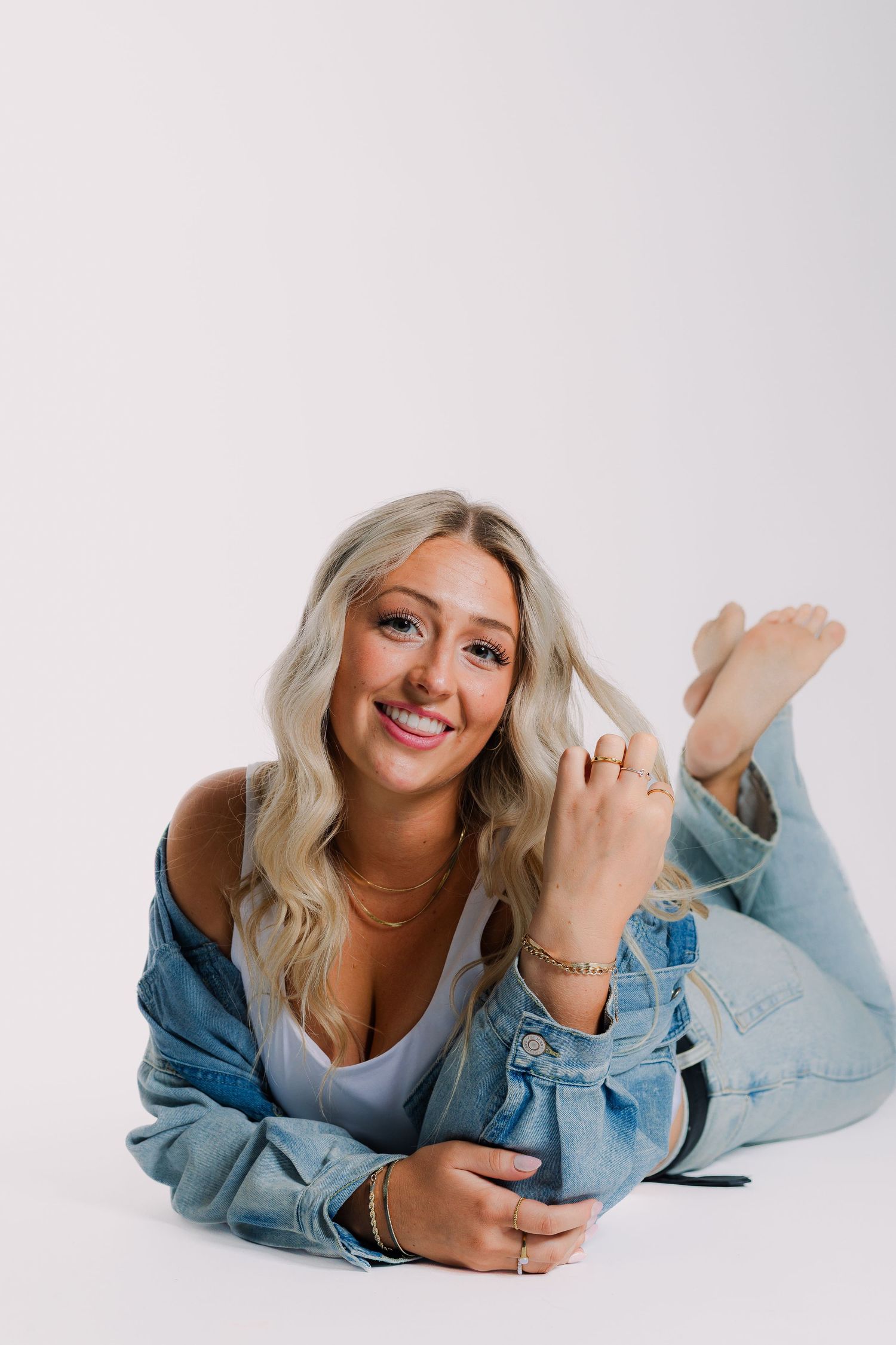 Casual lifestyle portraits showing someone in light denim shirt lying on white background in various relaxed poses.