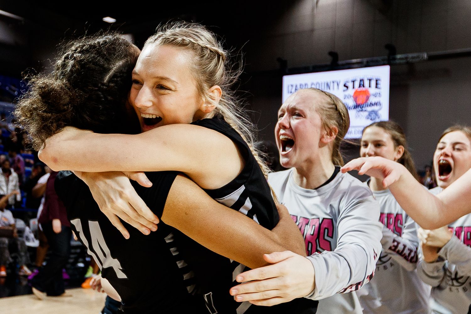 Teammates celebrate together after scoring during a basketball game.