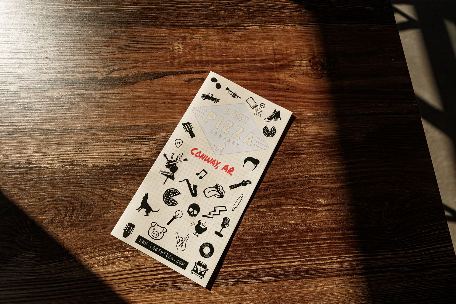 Restaurant menu on wooden table with vintage-style graphic design.