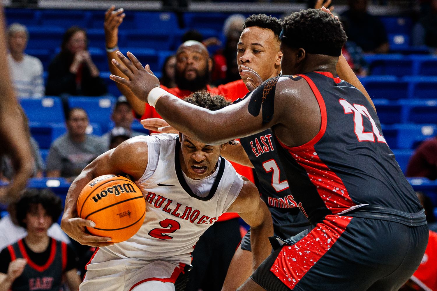Players from opposing teams battle for possession during intense basketball game.