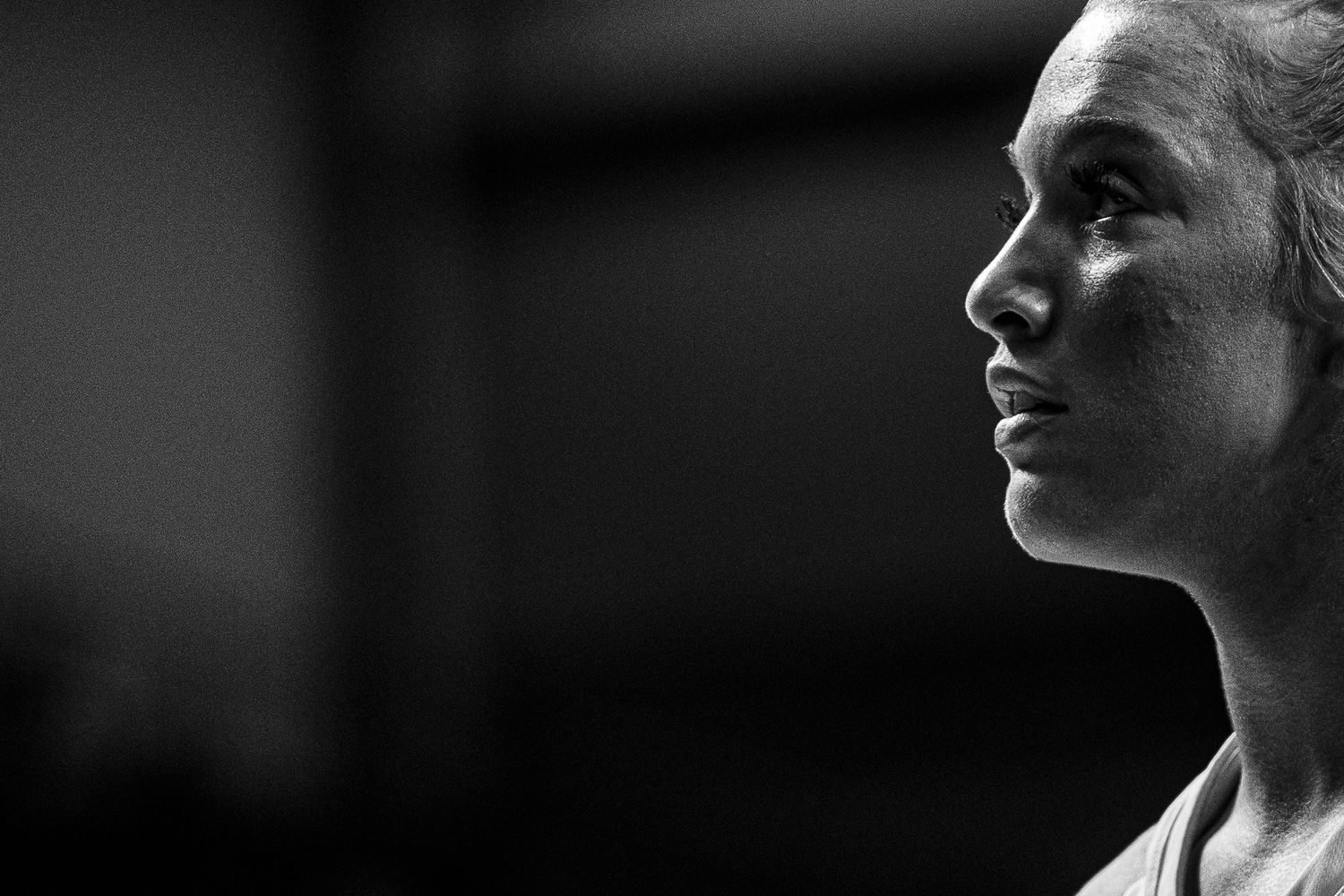 Basketball player captured in dramatic black and white close-up profile shot.