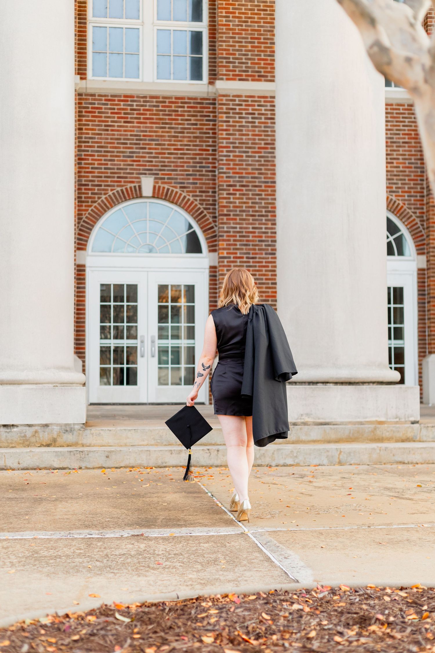 Graduation photoshoot sequence showing person in cap and gown walking across brick building exterior.