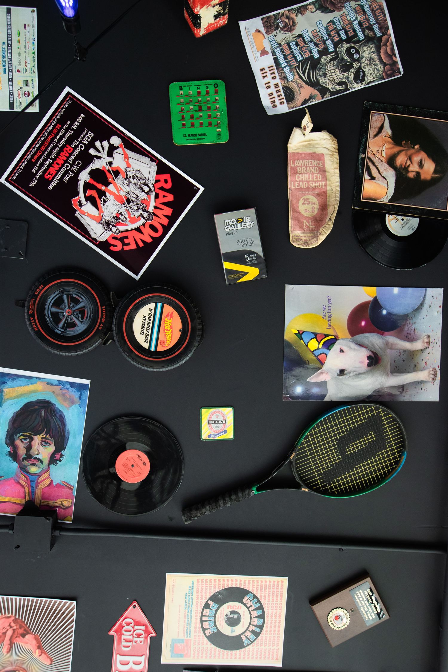 Overhead view of vintage memorabilia and vinyl records displayed on dark surface.