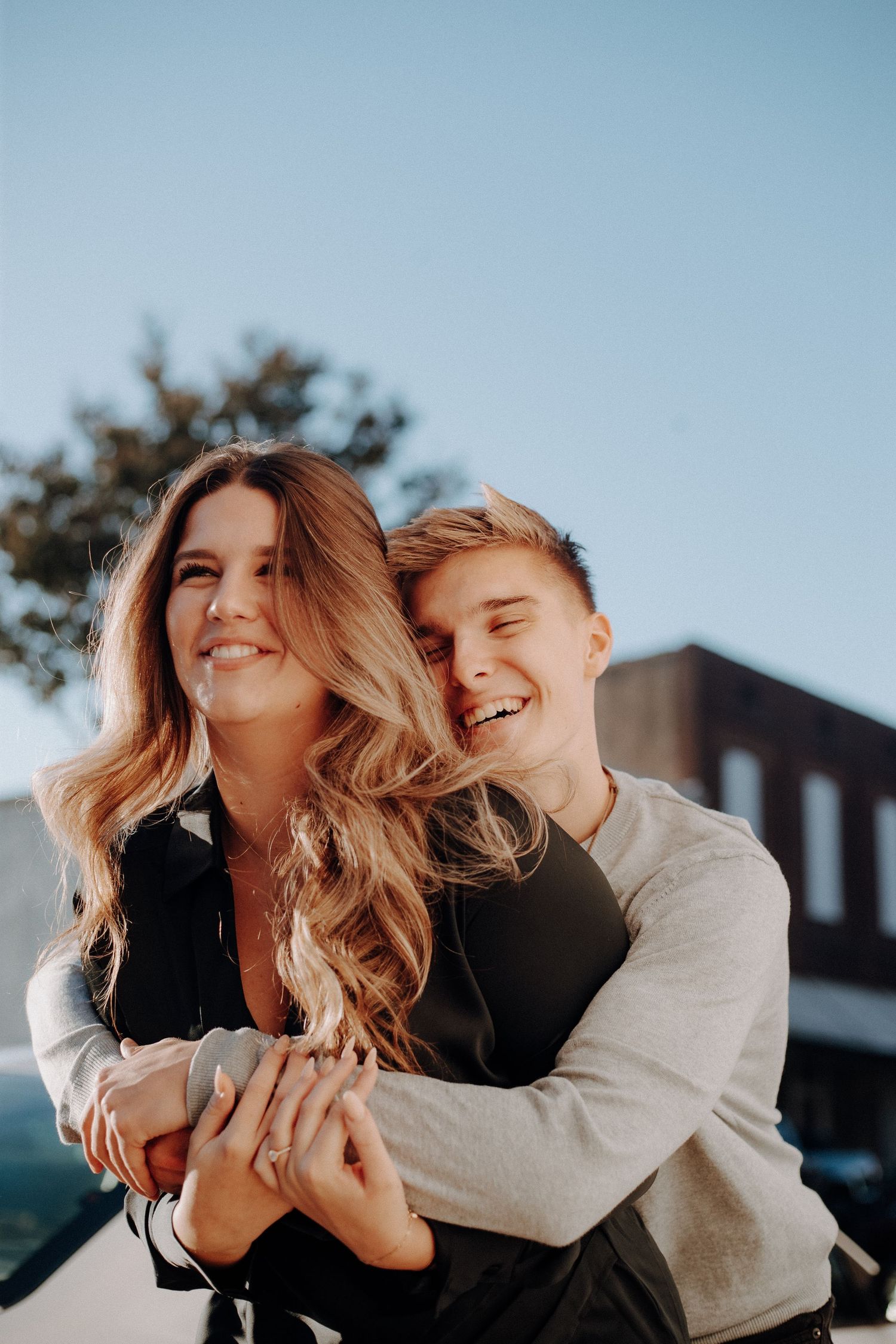 A couple shares playful and intimate moments together outdoors during golden hour.