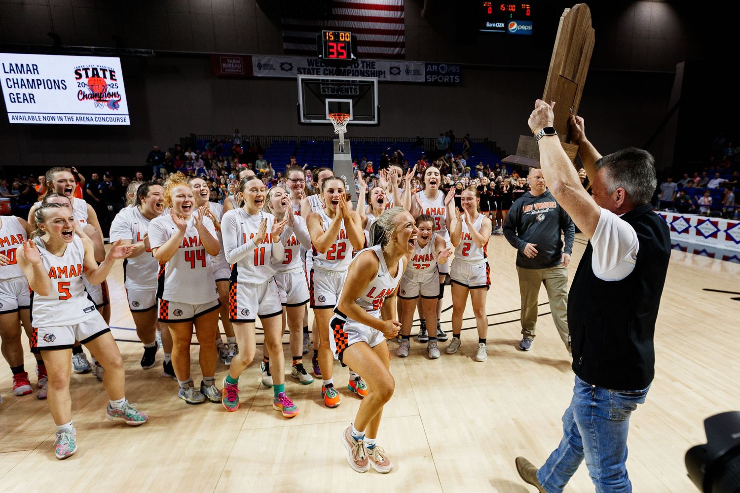 Wide view of basketball arena with fans and teams during game.