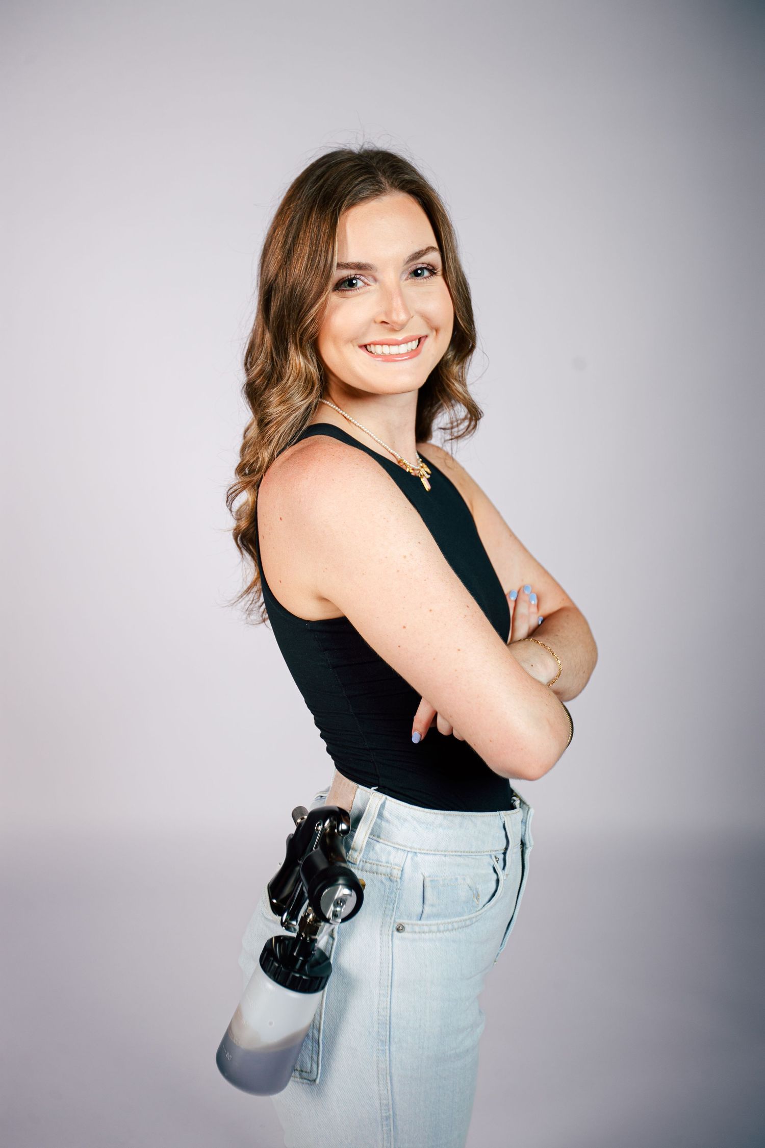 Person in black tank top and light blue jeans poses in various playful positions against gray studio backdrop.