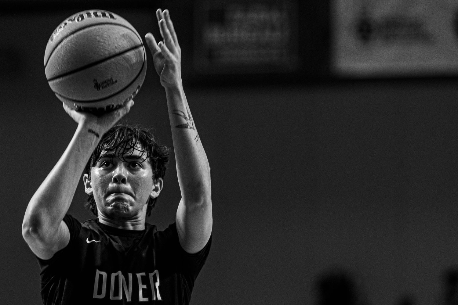 Basketball players battle for position during competitive indoor game.