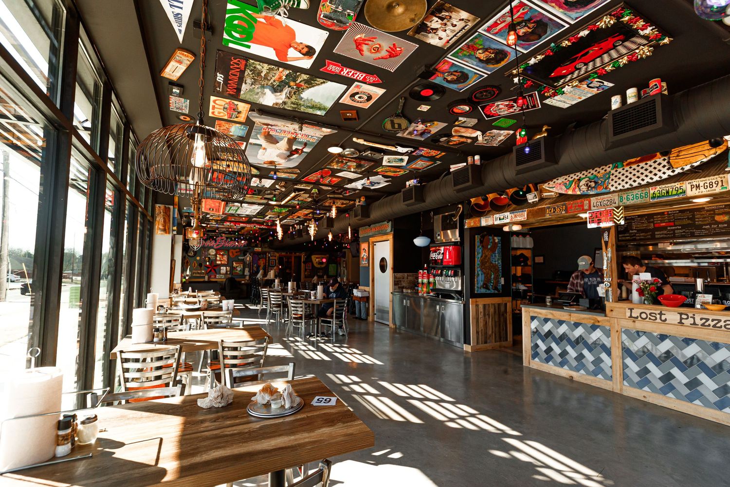 Restaurant interior with sports memorabilia and flags decorating ceiling.