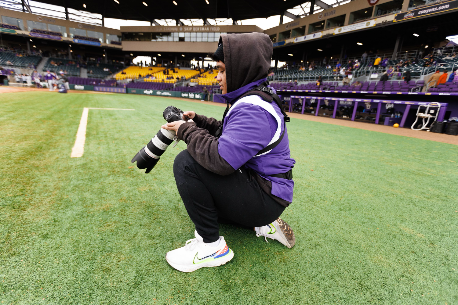 Series of low-angle shots showing football players on practice field with stadium lights.