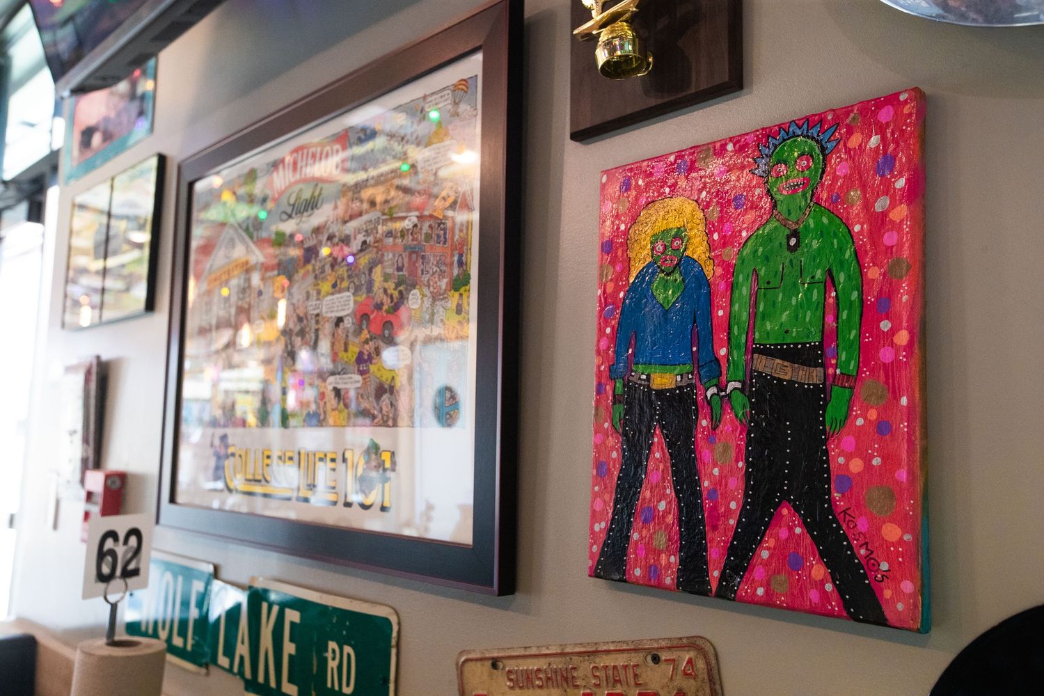 Vibrant wall art display featuring colorful pop art style paintings in restaurant setting.