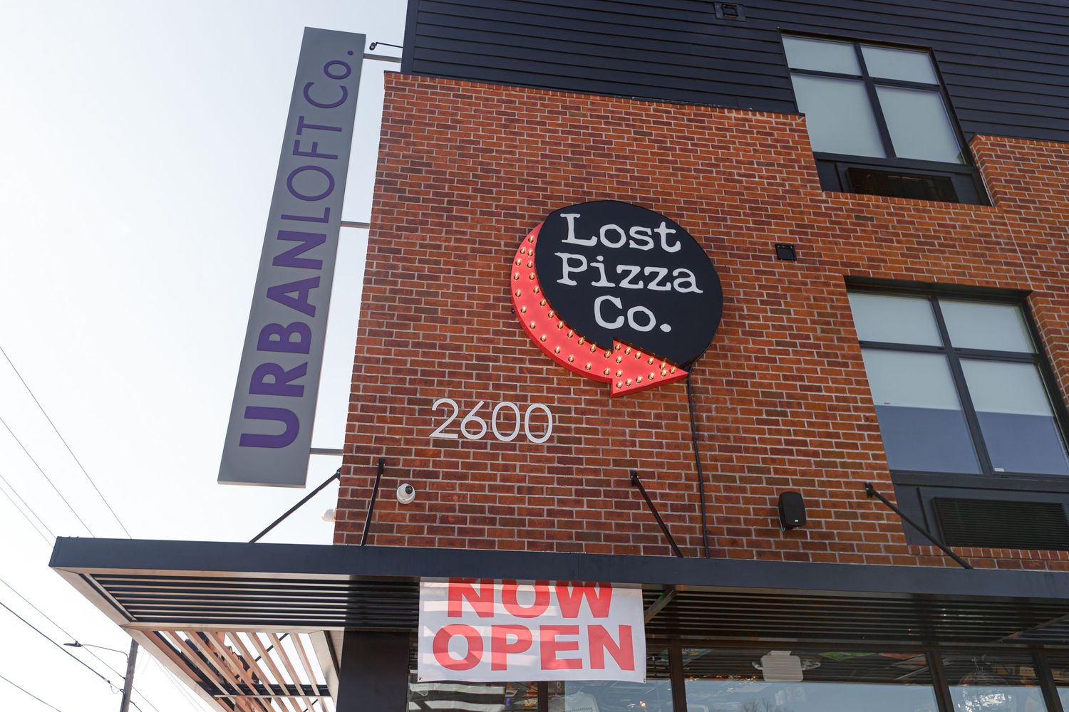 Lost Pizza Co. signage mounted on brick wall with red crescent moon logo.