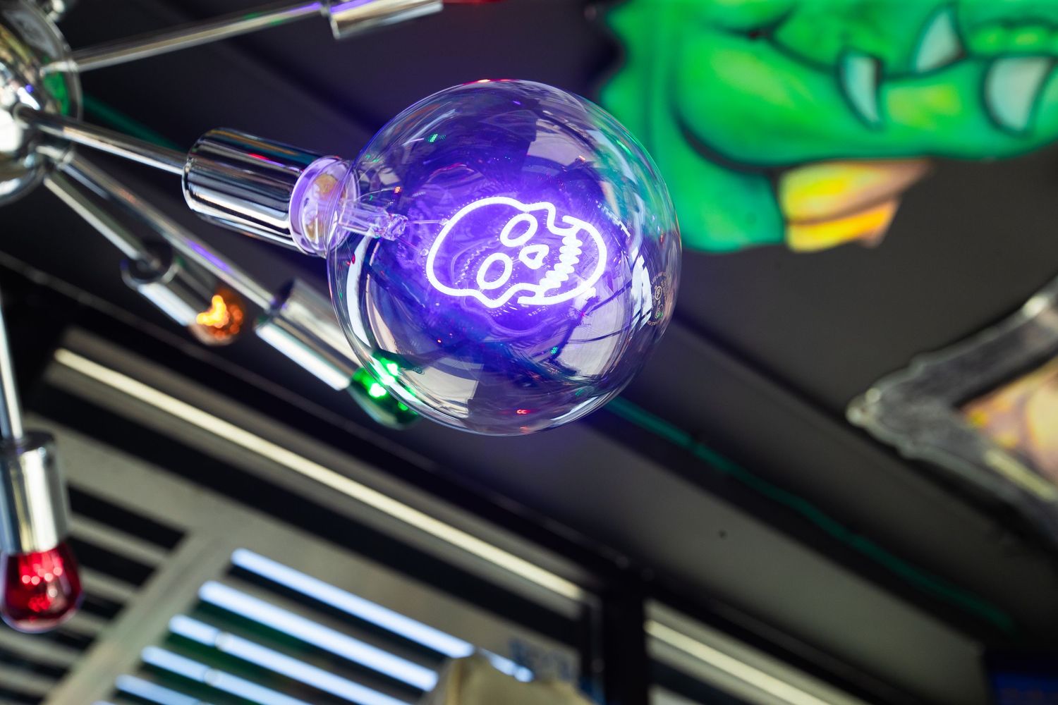 Purple neon sign glowing in dark bar setting with green decorative elements.