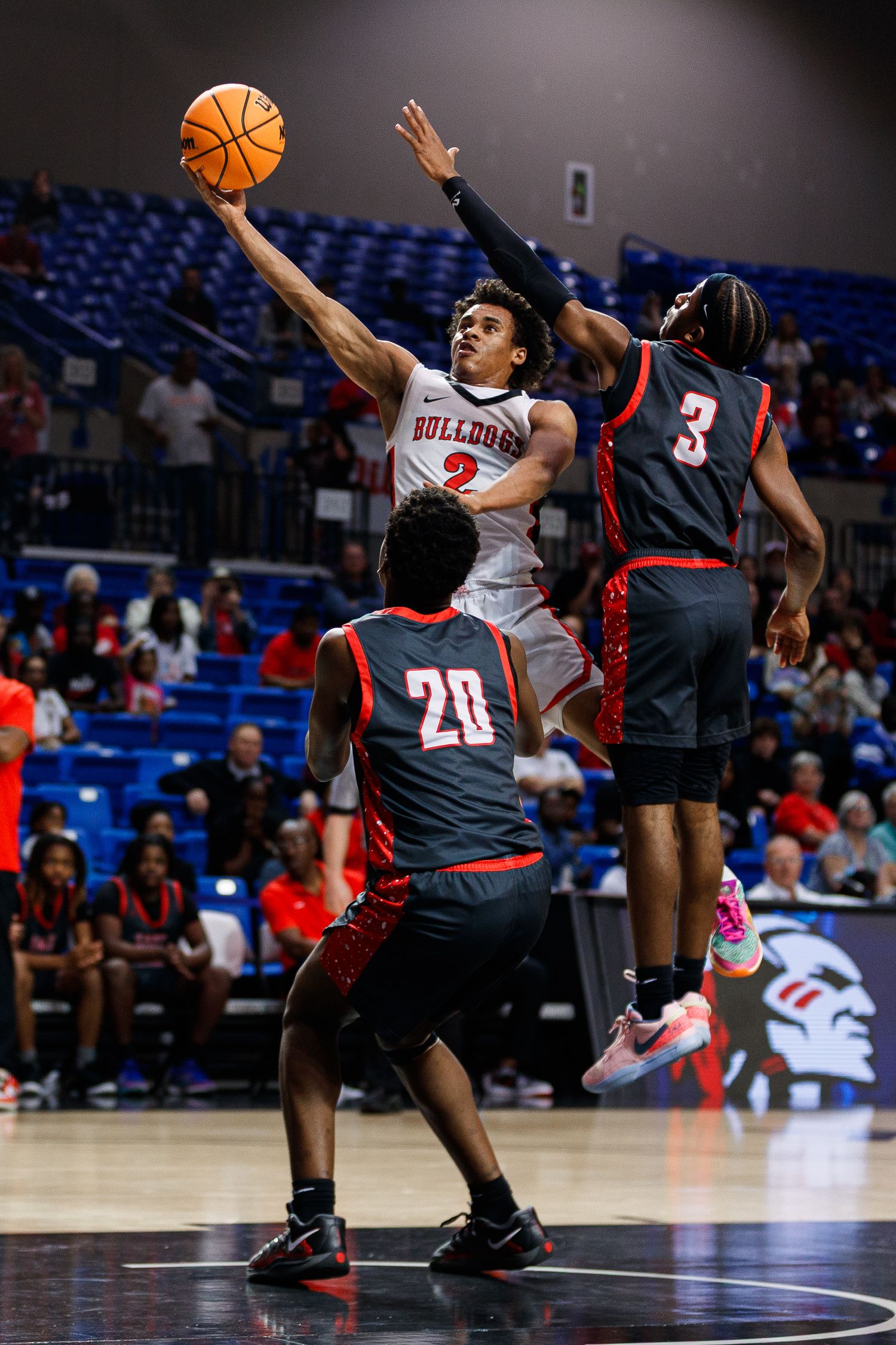 Basketball players from opposing teams battle for the ball during a competitive play.