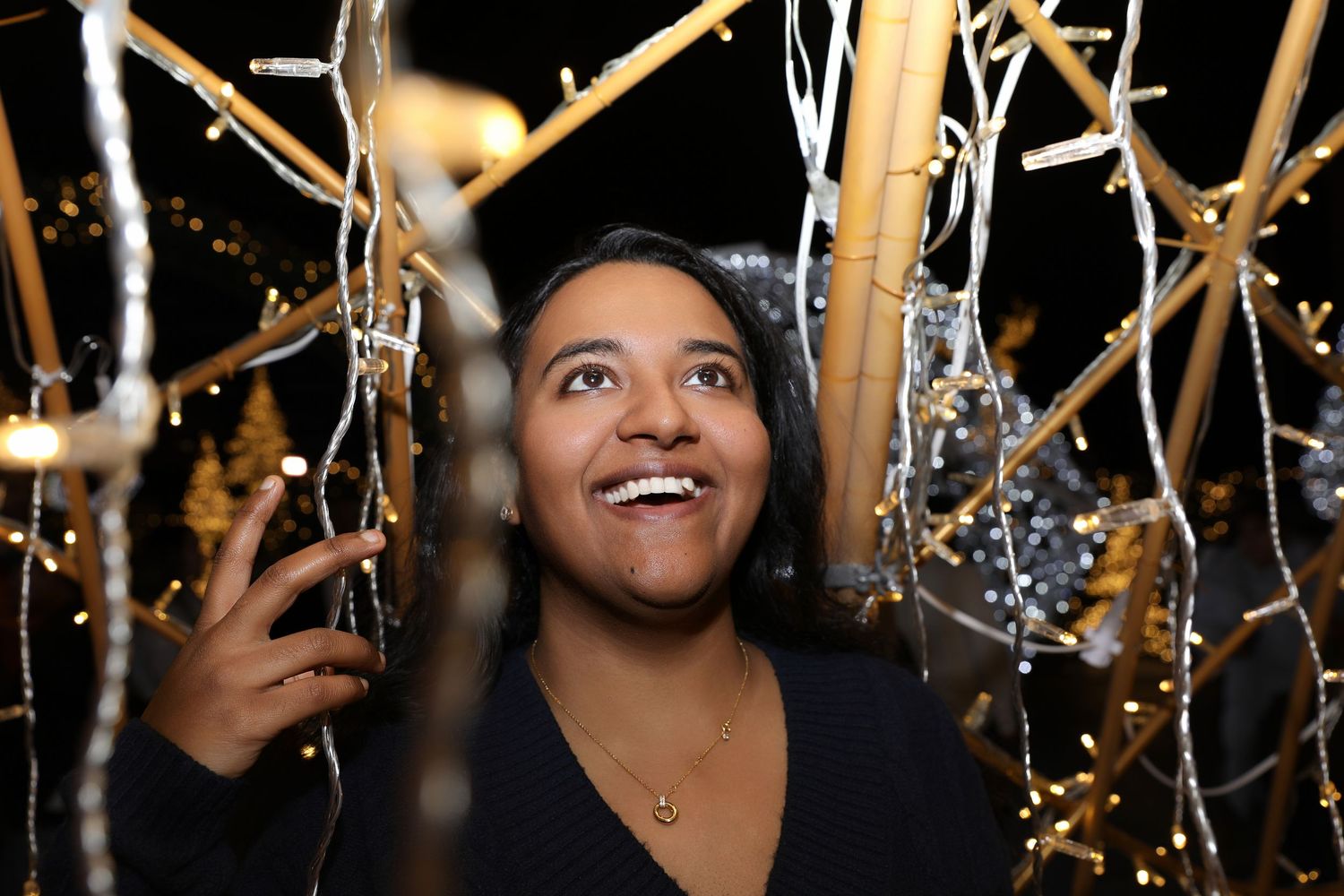 A person celebrates joyfully surrounded by silver and gold party decorations and confetti.